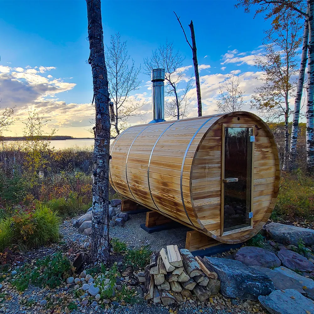 angled side view of ignis dome outdoor sauna with firewood and lake and forest views